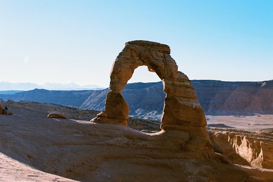 brown rock formation with hole during daytime in Arches National Park United States
