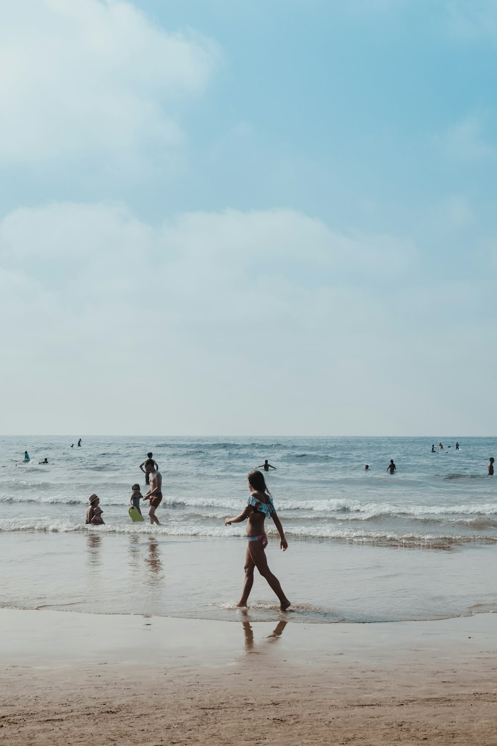 Mujer caminando en la orilla del mar durante el día