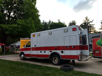 A non-emergency ambulance parked outside a medical facility ready for patient transport.