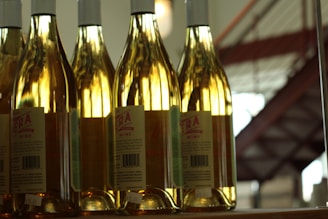 An assortment of colorful wine bottles arranged artfully on a shelf with soft lighting.