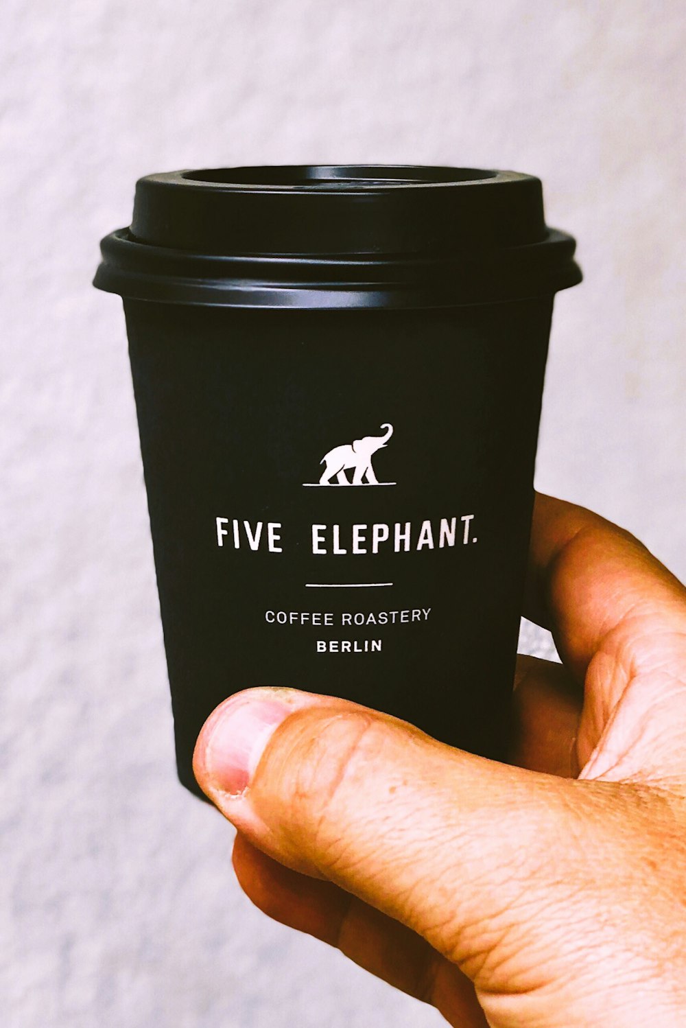 black and white Five Elephant coffee cup with lid