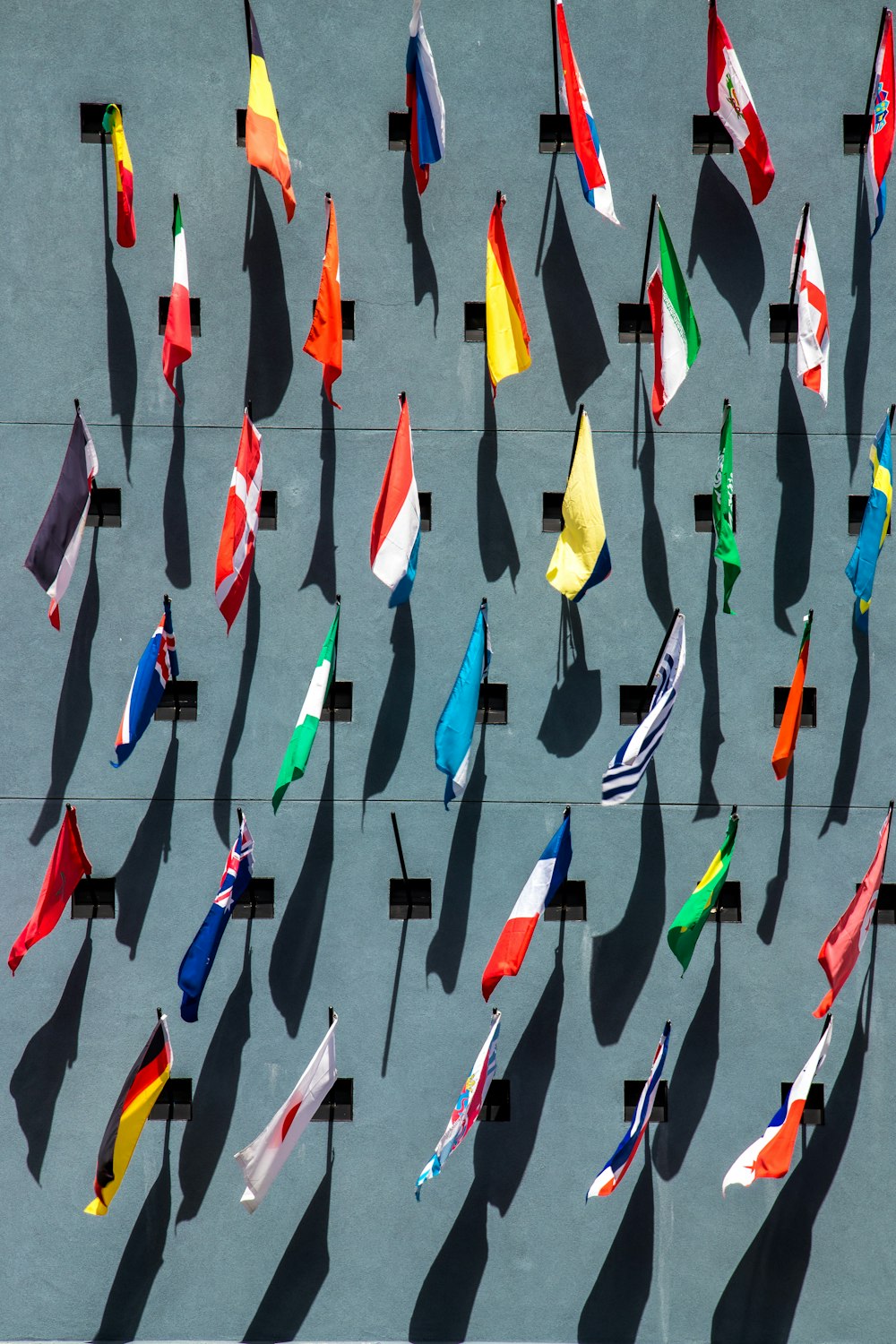 photo of assorted-color nation flags on wall during daytime