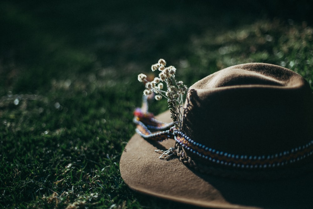 chapeau fedora marron sur le champ d’herbe