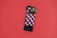 A pair of colorful patterned socks with a geometric cube design featuring red, black, and white colors is placed on a solid red background. The socks are neatly folded, and there is a cardboard label attached near the top bearing the brand name.