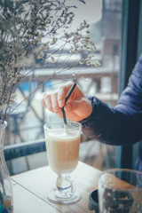 Barista carefully mixing a vibrant mocktail in a modern cafe setting.