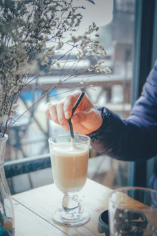 Barista carefully mixing a vibrant mocktail in a modern cafe setting.