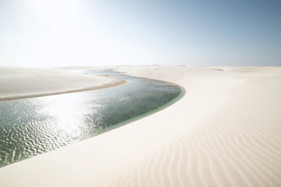 The stunning dunes and lagoons of Lençóis Maranhenses under a bright blue sky.
