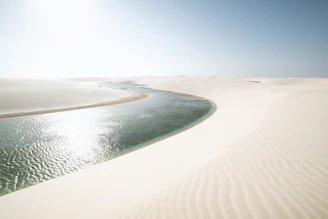 Wide shot of Djerba’s lagoon with muted blue waters and soft sand dunes.