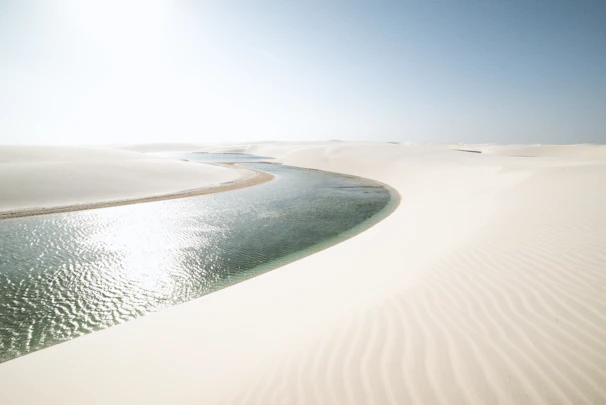 Wide shot of Djerba’s lagoon with muted blue waters and soft sand dunes.