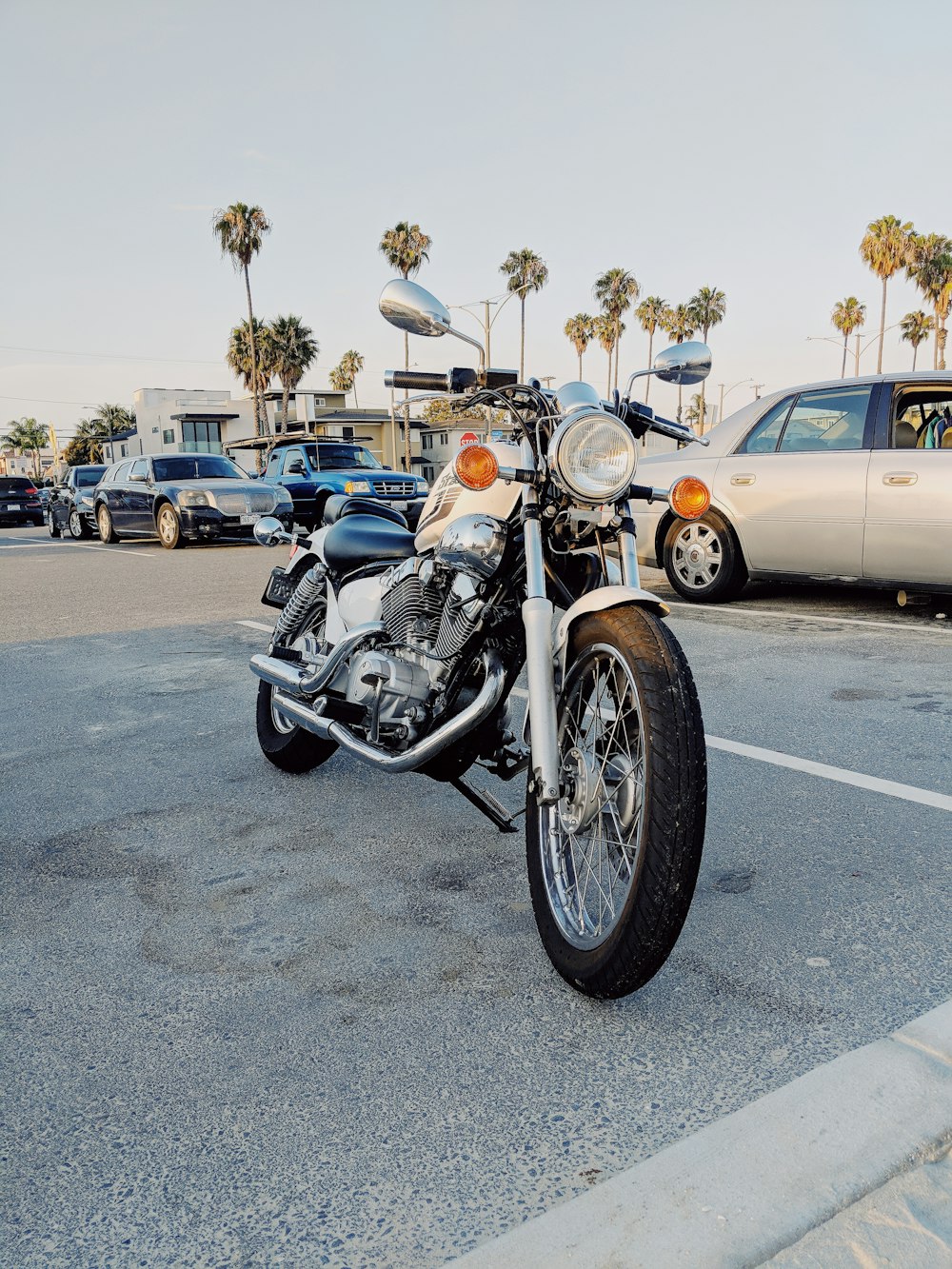 black and white touring motorcycle parked near vehicles during daytime