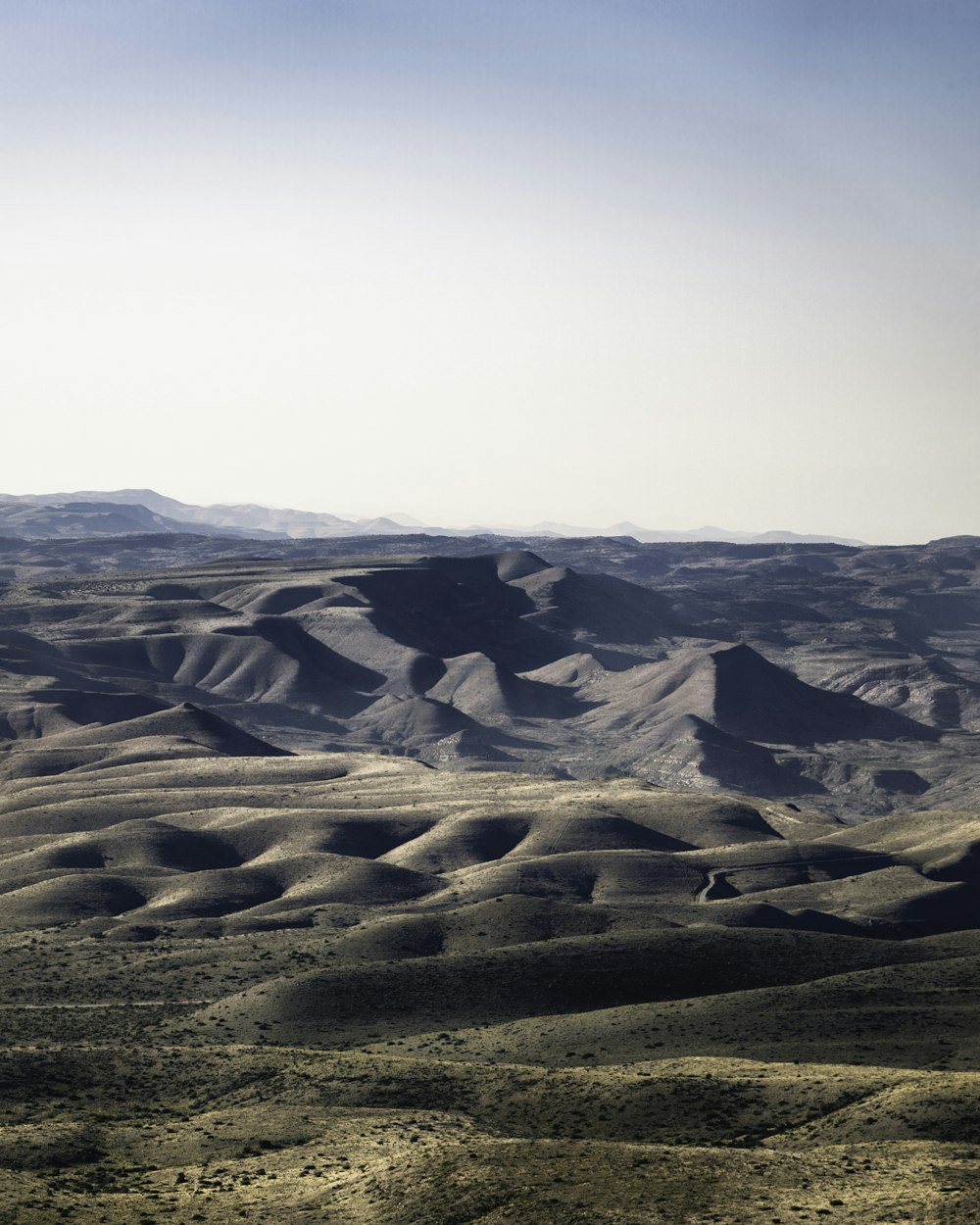 a view of a desert with hills in the distance