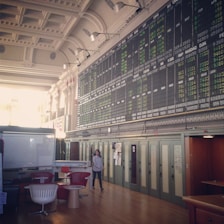 Elegant office space with warm lighting and financial charts on screens.