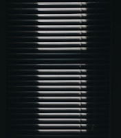 Modern kitchen window dressed with sleek roller shades partially rolled up.