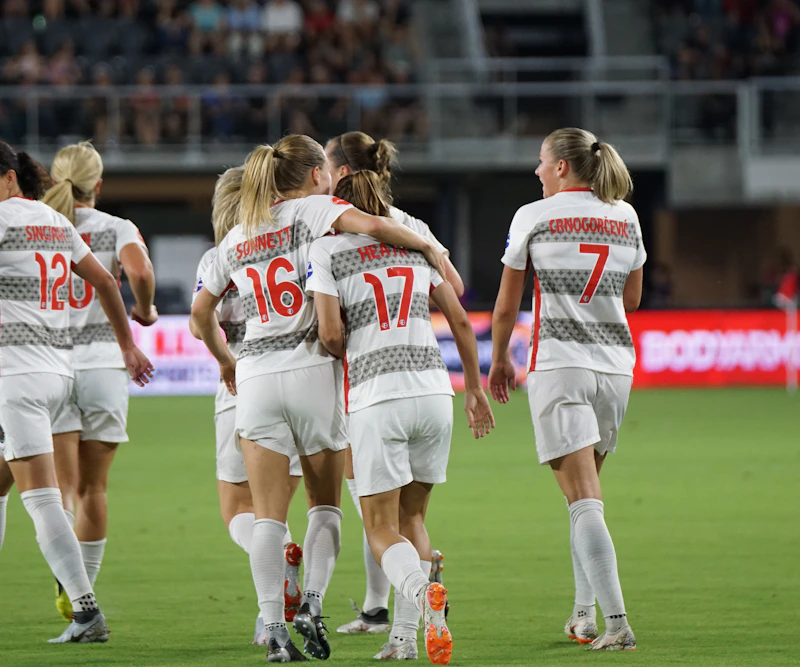 Women soccer players celebrating on the pitch with World Cup energy