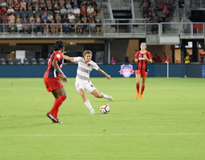 An intense moment of a striker taking a shot with defenders rushing to block