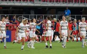 Youth soccer squad lined up on the field, sporting custom white and red apace jerseys and matching socks.