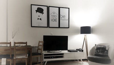 A modern living room with a sleek wooden TV unit and nesting tables showcasing natural wood grain.
