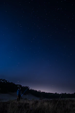 An instructor guiding kids through a telescope to explore the night sky in an outdoor astronomy session.