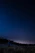 A cozy night scene with a person stargazing through a telescope under a clear sky filled with stars.