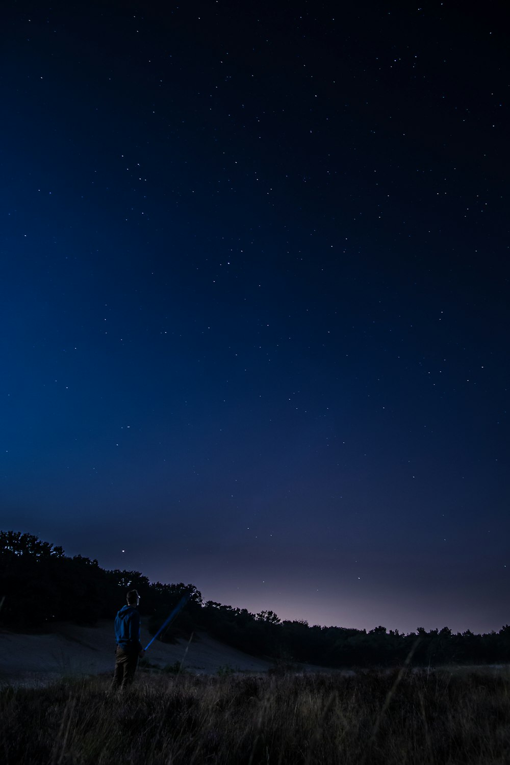 uomo in piedi in un campo aperto di notte