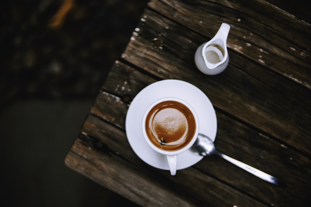 mug filled with cappuccino on saucer