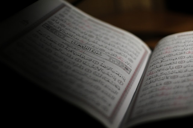 A serene open book with Arabic and Urdu script glowing softly under warm light
