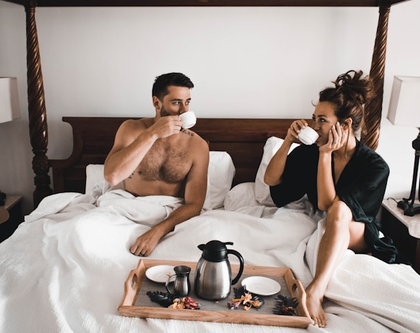 man drinking some coffee beside woman