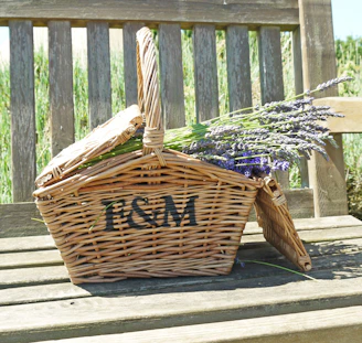 A beautifully sewn linen pouch filled with wildflowers lying on a wooden picnic table.