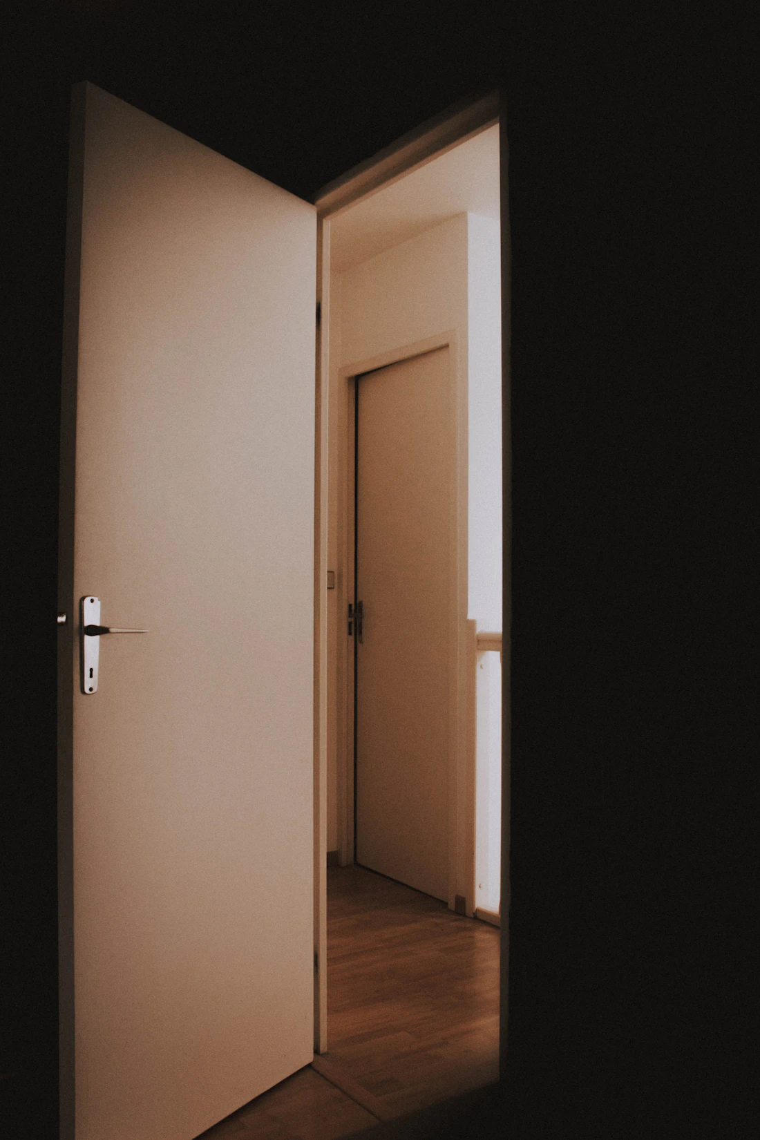 An open door letting light into a quiet room.
