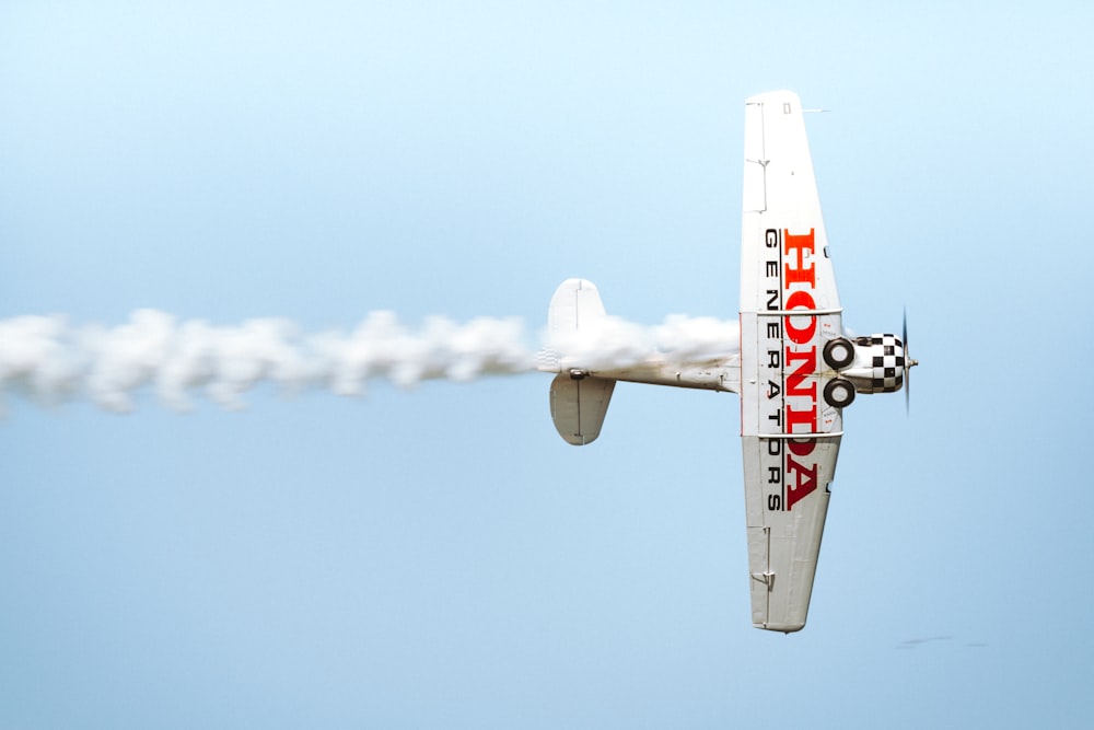 white biplane on sky at daytime