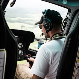 Pilot wearing mixed reality headset interacting with virtual helicopter controls.