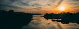 Sunset casting warm hues over a calm river, reflecting peaceful energy.