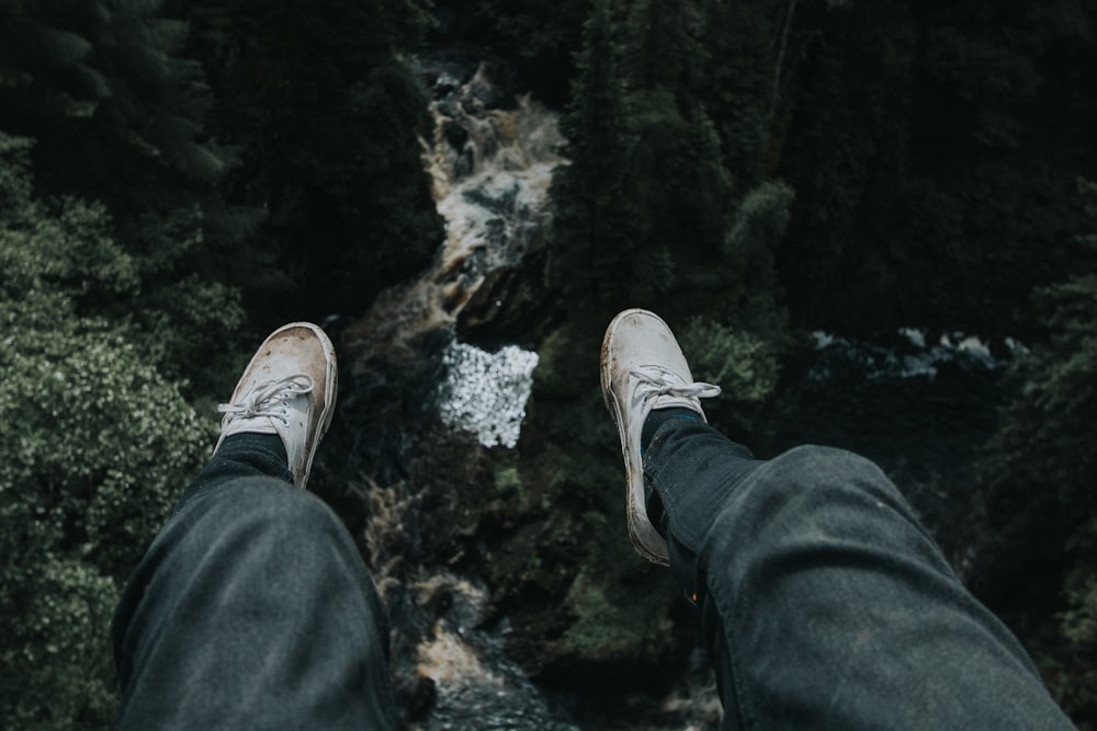 person sitting on cliff during daytime