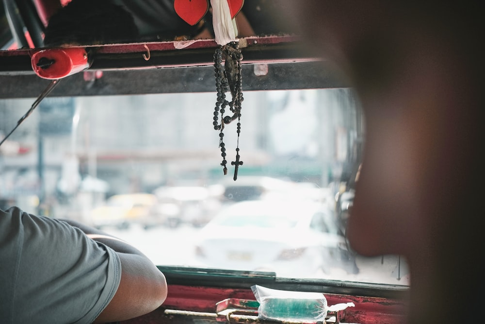 茶色のロザリオのそばの車内の人