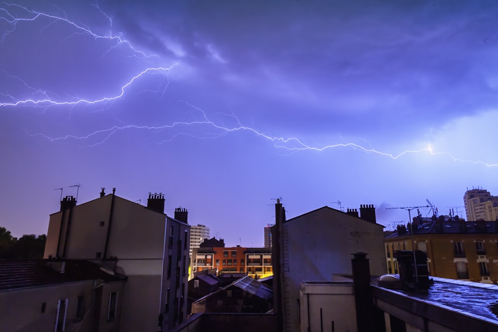 white buildings under lightnings