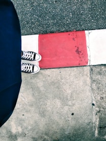 A pair of high-top shoes on a street pavement.