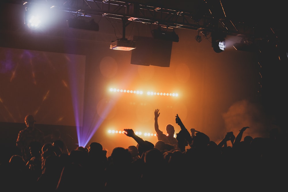 man raising right hand facing crowd