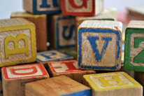 A child playing with colorful alphabet blocks spelling English words, indoors