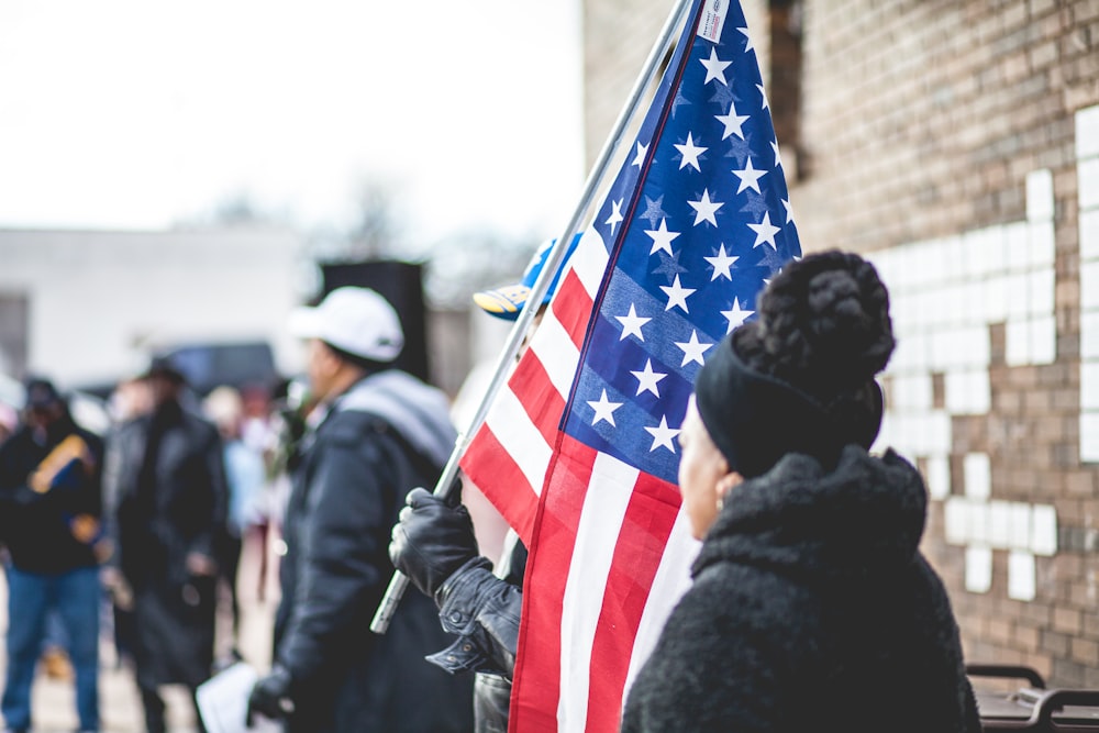 woman standing beside person holding flag of America