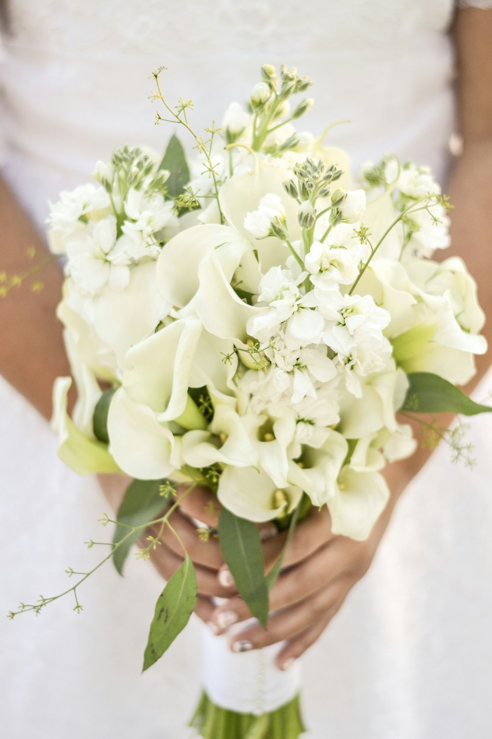 selective focus photography of woman holding bouquet of flowers