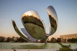 A wide view of the stone pinwheel sculpture at the center of the park on a sunny day.