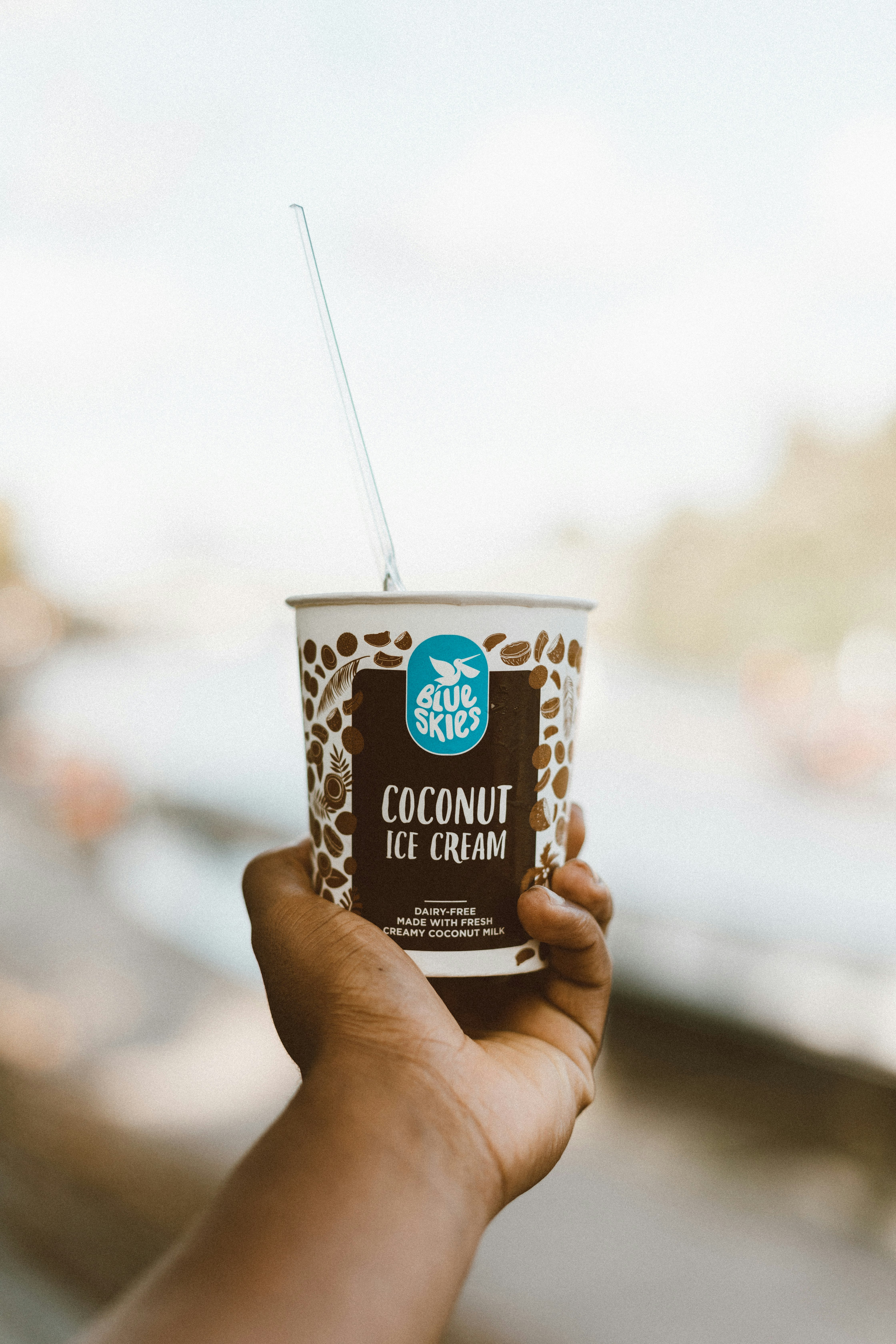 person holding Blue Skies coconut ice cream cup