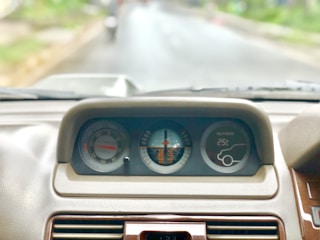 A car dashboard with a toll tag and a highway in the background.