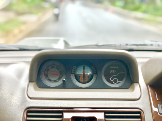 A car dashboard with a toll tag and a highway in the background.