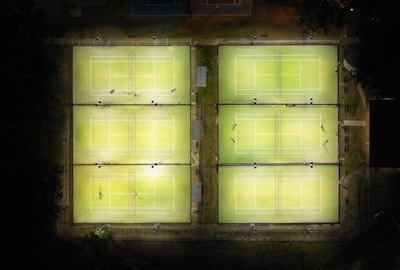 Evening view of the illuminated padel courts with a lively atmosphere.