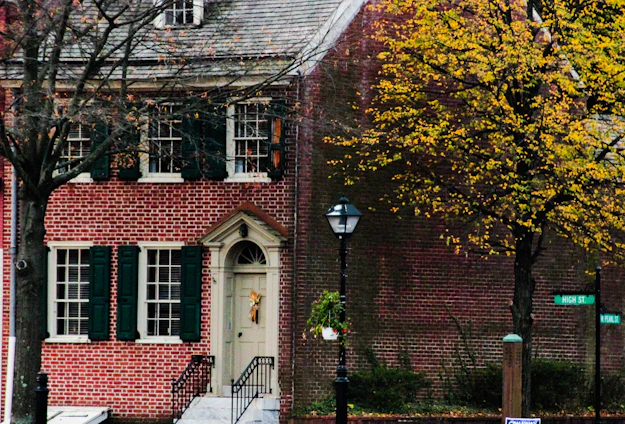 A friendly real estate agent handing keys to a happy family in front of a charming Central Ohio home.