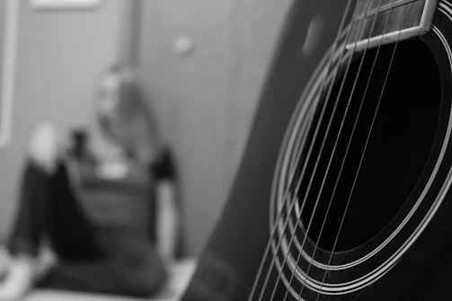 Black and white photo of François playing an acoustic guitar outdoors.