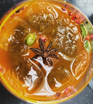 Close-up of a colorful cocktail with vibrant Asian spices and citrus garnish.