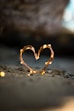 close-up photography of heart shaped fairy lite on brown sand