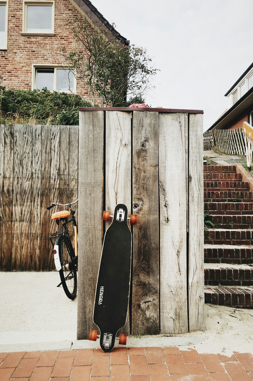 Longboard negro apoyado en tabla de madera marrón